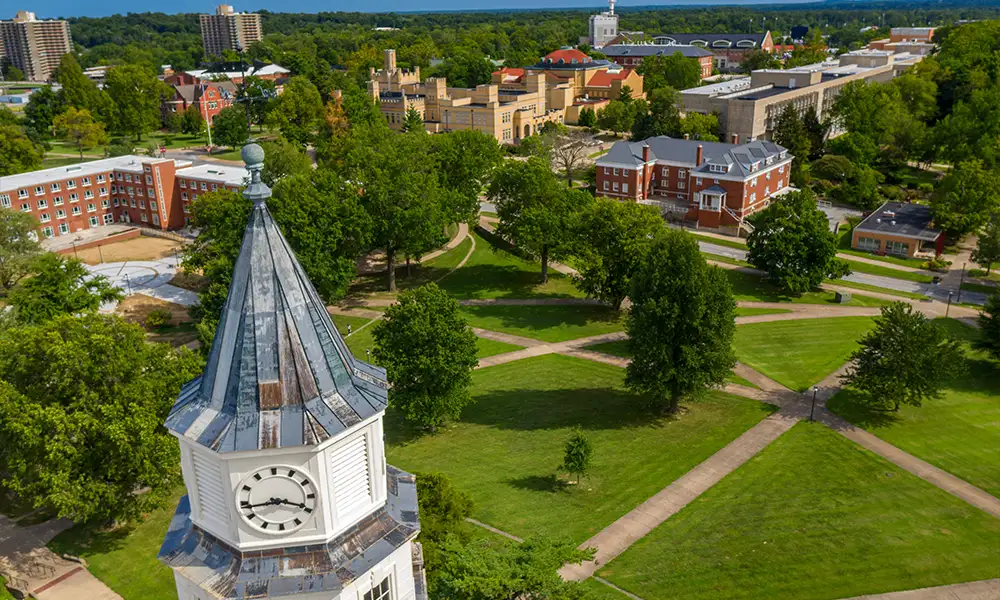Aerial view of the Pulliam Hall clock tower and surrounding campus buildings at Southern Illinois University, with intersecting walkways and green spaces below.